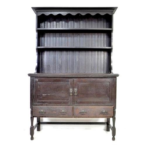 227 - An Edwardian stained oak dresser, two shelf plate rack, above two drawers and two cupboards, raised ... 