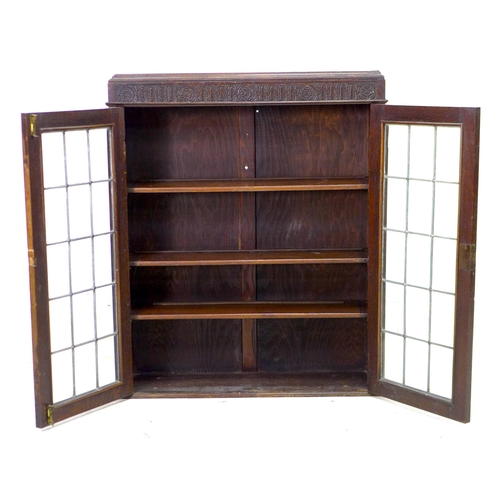 234 - A 1950s oak bureau bookcase, twin leaded glazed doors enclosing three shelves, fall front with fitte... 