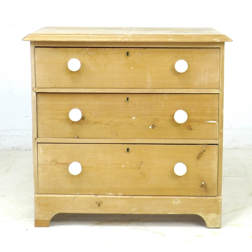 241 - An early 20th century pine chest of three drawers, raised on bracket feet with white ceramic handles... 