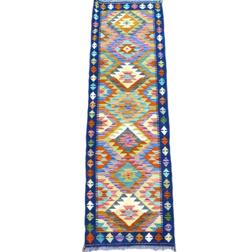 242 - A Chobi Kilim runner, decorated with a row of seven lozenges across its center, 196 by 61cm.