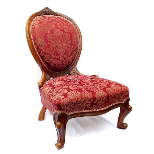 247 - A Victorian walnut framed nursing chair, with spoon shaped back, carved top rail, upholstered in a r... 