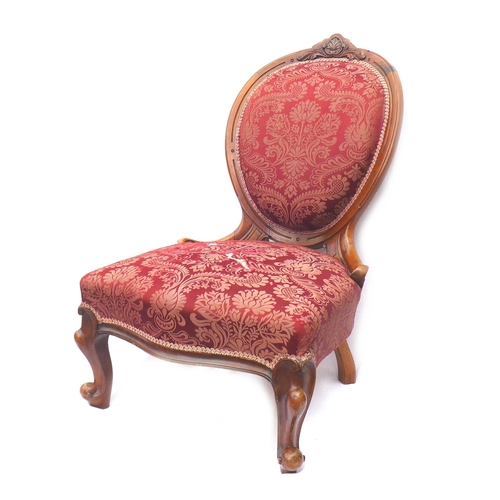 247 - A Victorian walnut framed nursing chair, with spoon shaped back, carved top rail, upholstered in a r... 