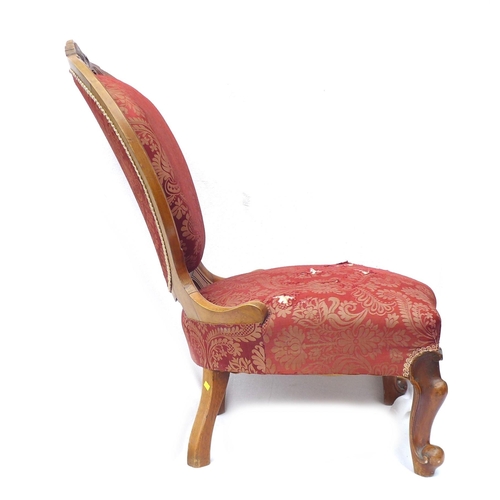 247 - A Victorian walnut framed nursing chair, with spoon shaped back, carved top rail, upholstered in a r... 