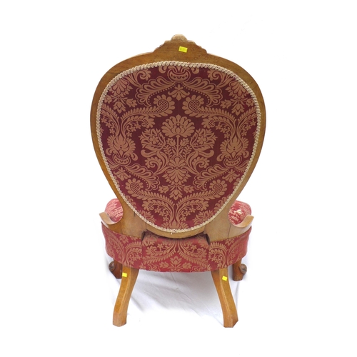 247 - A Victorian walnut framed nursing chair, with spoon shaped back, carved top rail, upholstered in a r... 