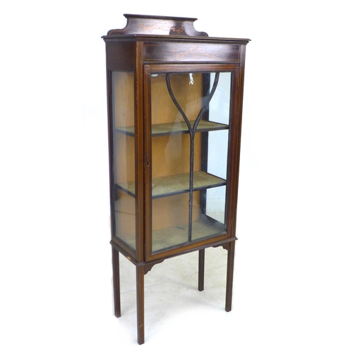 253 - An Edwardian mahogany display cabinet, with inlaid decoration, single leaded glazed door enclosing t... 