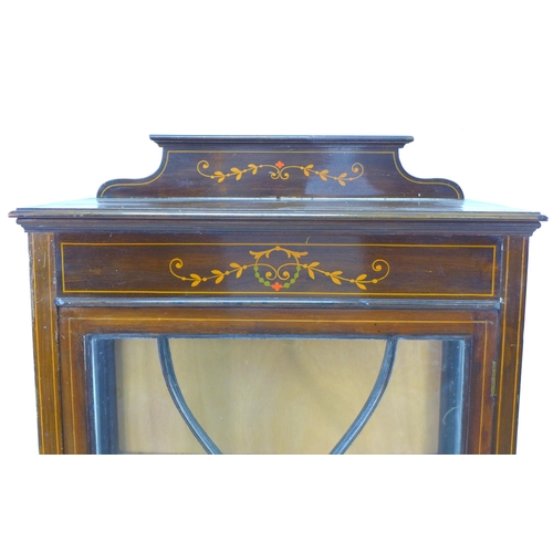 253 - An Edwardian mahogany display cabinet, with inlaid decoration, single leaded glazed door enclosing t... 