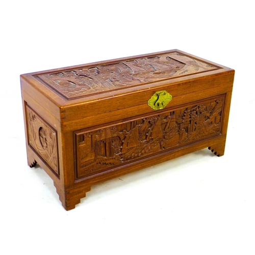 269 - A 20th century Oriental camphor wood chest, decorated with relief carved panels, featuring a sliding... 