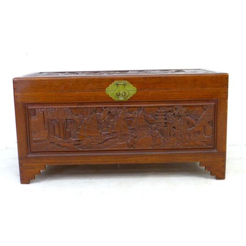 269 - A 20th century Oriental camphor wood chest, decorated with relief carved panels, featuring a sliding... 