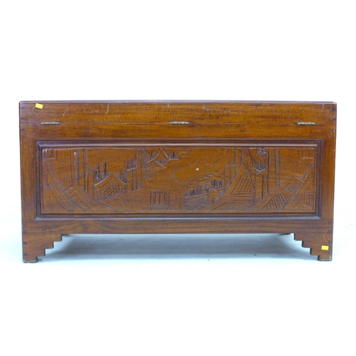 269 - A 20th century Oriental camphor wood chest, decorated with relief carved panels, featuring a sliding... 