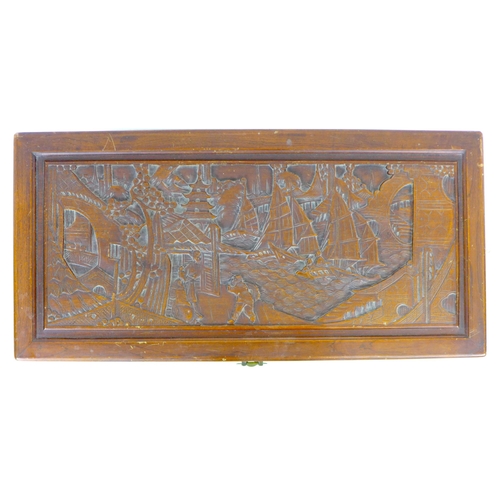 269 - A 20th century Oriental camphor wood chest, decorated with relief carved panels, featuring a sliding... 