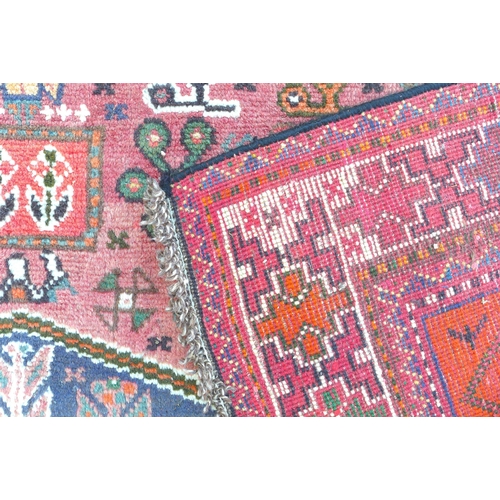 277 - A Hamadan rug with red ground, floral decoration to the field, central dark blue geometric medallion... 