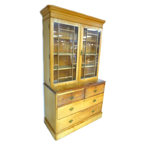 278 - A Victorian pine bookcase, twin glazed doors, enclosing three shelves, below two drawers over twin d... 