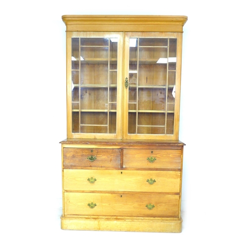 278 - A Victorian pine bookcase, twin glazed doors, enclosing three shelves, below two drawers over twin d... 