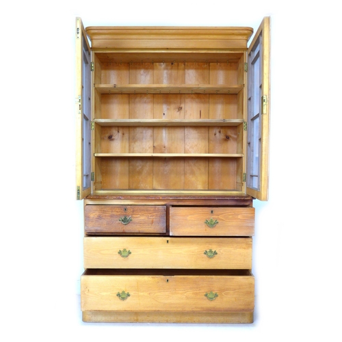 278 - A Victorian pine bookcase, twin glazed doors, enclosing three shelves, below two drawers over twin d... 