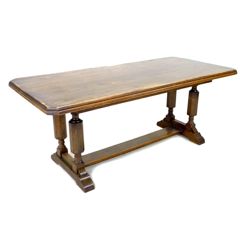 283 - A mid 20th century oak trestle dining table, rectangular top with canted corners and moulded reeded ... 