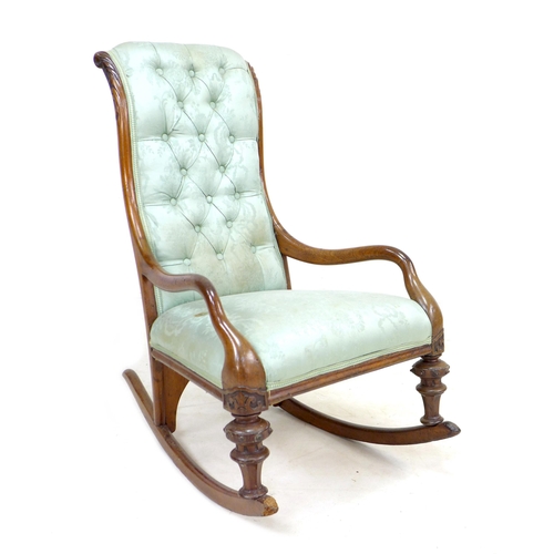 286 - A Victorian mahogany rocking chair, upholstered in button back fabric, with carved decoration to the... 