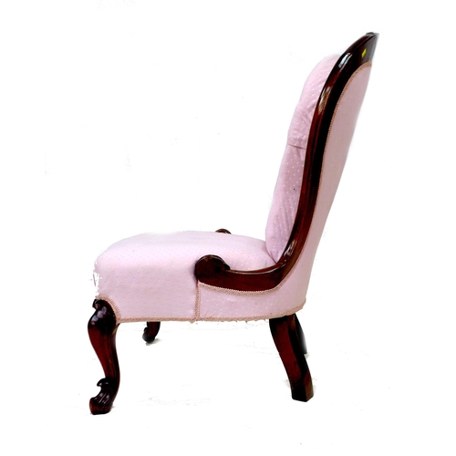 289 - A Victorian mahogany nursing chair, carved frame, upholstered in pink fabric, raised on cabriole fro... 