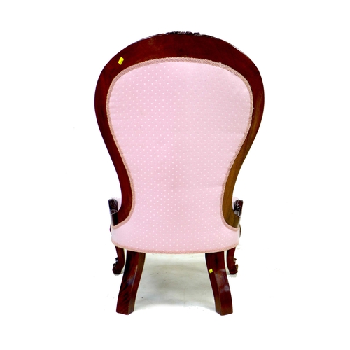 289 - A Victorian mahogany nursing chair, carved frame, upholstered in pink fabric, raised on cabriole fro... 