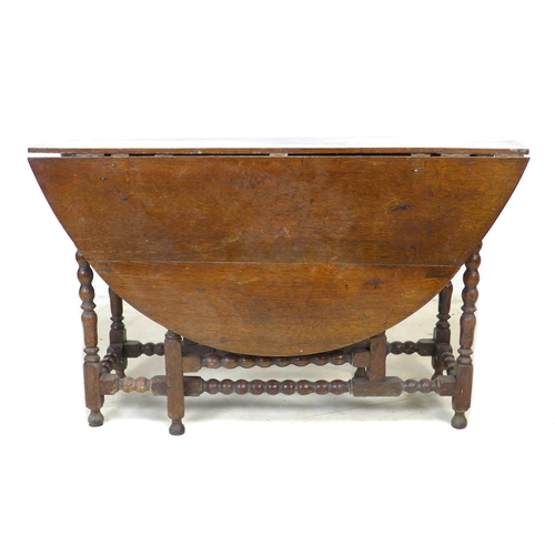 290 - A 17th century oak drop leaf table, with circular top raised on eight bobbin turned legs, double gat... 