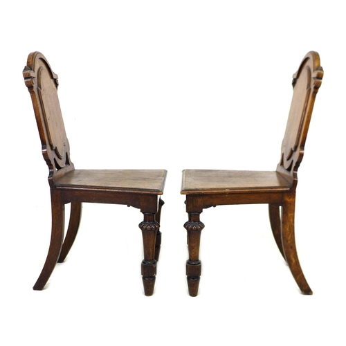 291 - A pair of Victorian oak hall chairs, with fielded panel backs, raised on lobe carved front legs and ... 