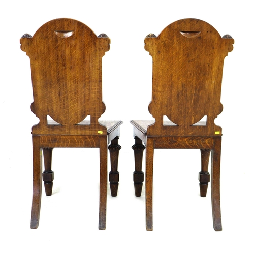 291 - A pair of Victorian oak hall chairs, with fielded panel backs, raised on lobe carved front legs and ... 