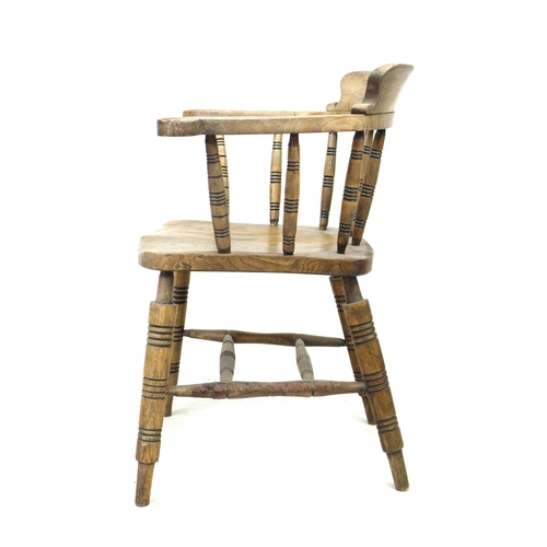 293 - A 19th century oak smokers bow armchair, with stamped maker's mark 'Elliot & Sons JJH', raised on tu... 