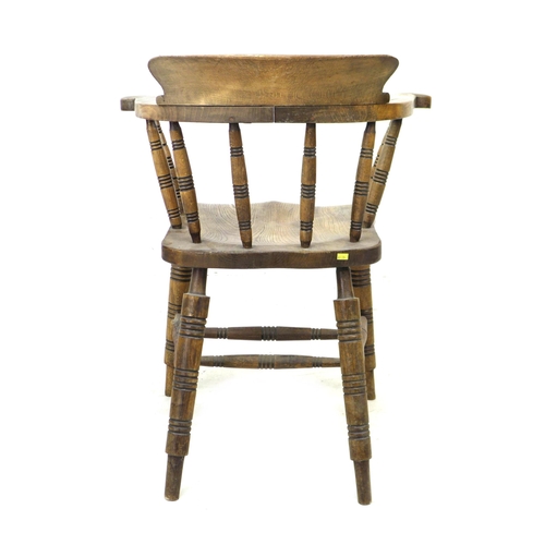 293 - A 19th century oak smokers bow armchair, with stamped maker's mark 'Elliot & Sons JJH', raised on tu... 