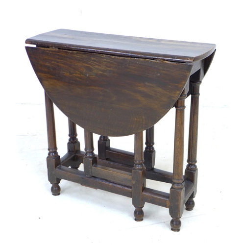 304 - A 17th century oak drop leaf table, with oval surface, twin gate leg action, pegged joints, raised o... 