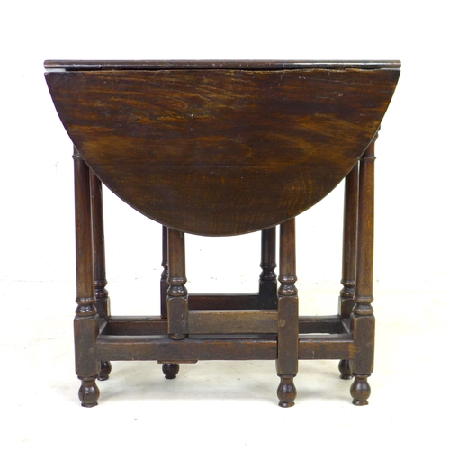 304 - A 17th century oak drop leaf table, with oval surface, twin gate leg action, pegged joints, raised o... 