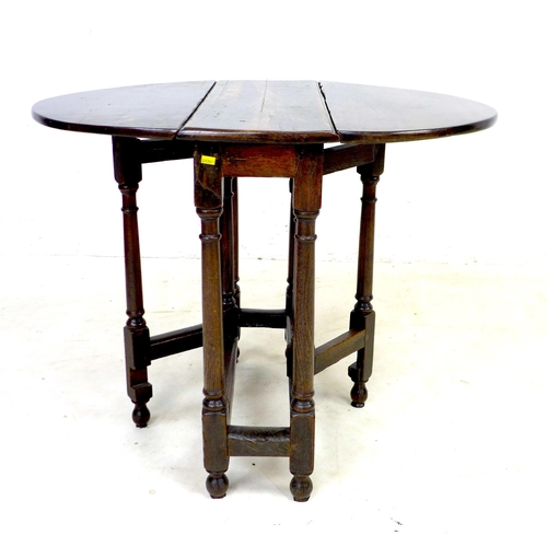 304 - A 17th century oak drop leaf table, with oval surface, twin gate leg action, pegged joints, raised o... 