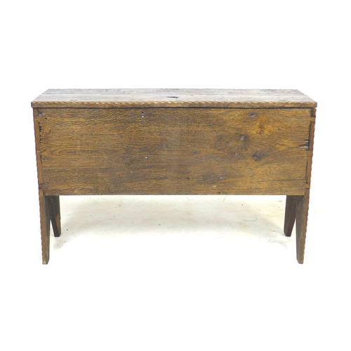 307 - A 17th century oak coffer, with lift lid and sides descending to V cut-out supports, 102 by 34 by 64... 