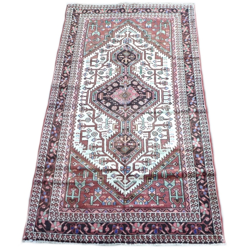 308 - A Toserkan rug with a pink/brown ground, with a black diamond medallion with pendant anchors on a cr... 