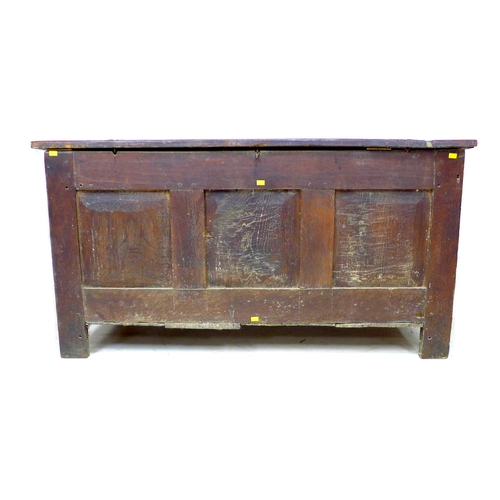 309 - An 18th century three panelled oak coffer, with lift lid, raised on straight legs, modern brass hing... 