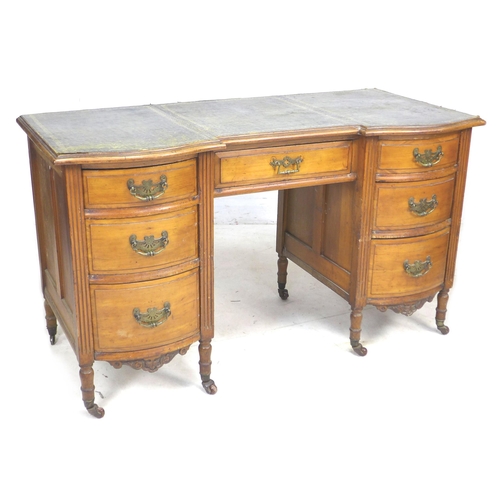 317 - A Continental fruitwood writing desk, with green leatherette surface, seven drawers with brass plate... 