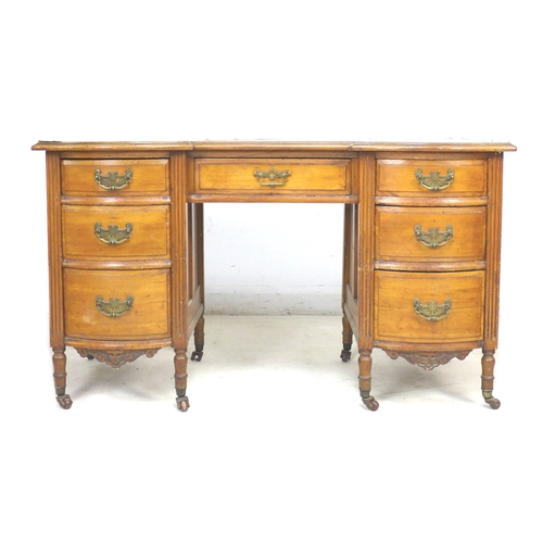 317 - A Continental fruitwood writing desk, with green leatherette surface, seven drawers with brass plate... 