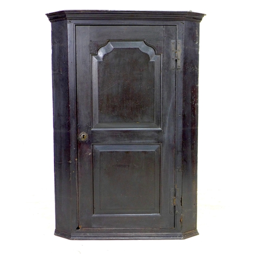 322 - A George III oak corner cupboard, with a single flat front fielded panel door, fixed shelves to inte... 