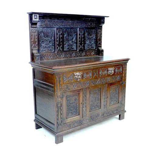 323 - A Victorian stained oak sideboard, the front carved with green man face masks, blind friezes of flow... 