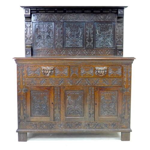 323 - A Victorian stained oak sideboard, the front carved with green man face masks, blind friezes of flow... 