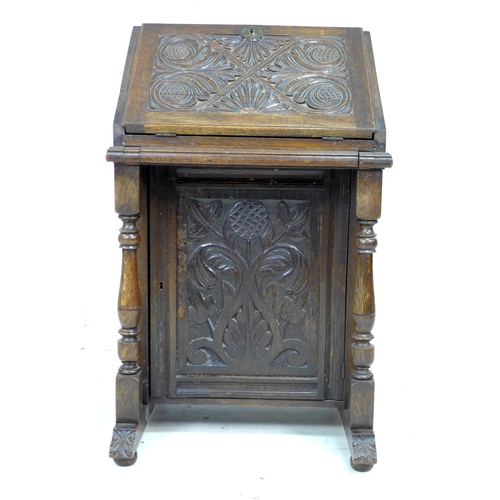 326 - A Victorian oak writing desk, of narrow form with slope front carved with scrolling foliage, opening... 