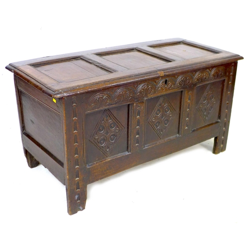 327 - A 17th century oak chest, lift top over a three panel front carved with diamonds and lunettes, raise... 