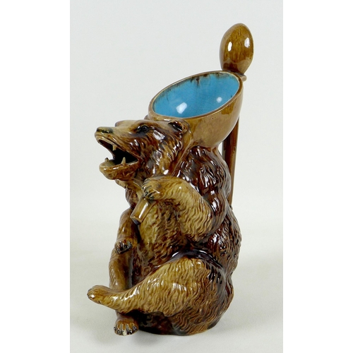 33 - A late 19th century German pottery novelty pitcher jug, modelled as a seated bear, mouth open from w... 