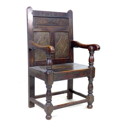 340 - A 17th century and later oak Wainscot armchair, the solid three panel back carved with geometric pat... 