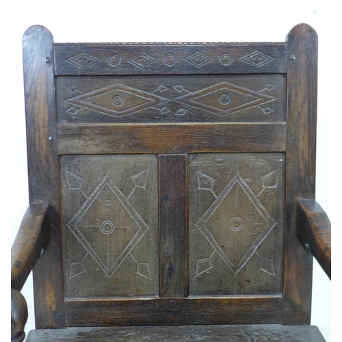 340 - A 17th century and later oak Wainscot armchair, the solid three panel back carved with geometric pat... 