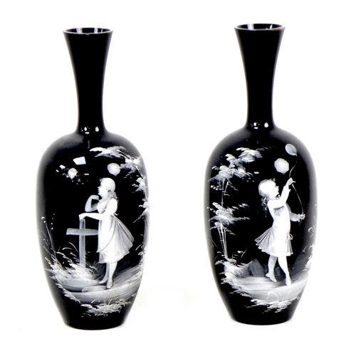 69 - Two Mary Gregory style vases, each with applied decoration of a young girl playing outside, on black... 