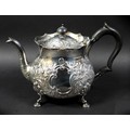 A Victorian silver teapot, repousse decorated with flowers and C scrolls in rococo style, ebonised h... 