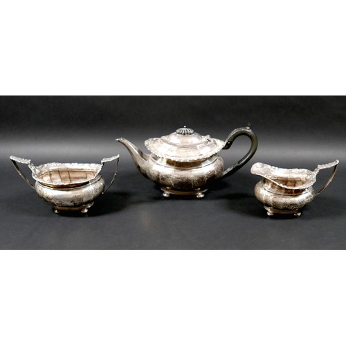 40 - An George V silver three piece tea service, with faceted bodies and fruiting vine cast rims, compris... 