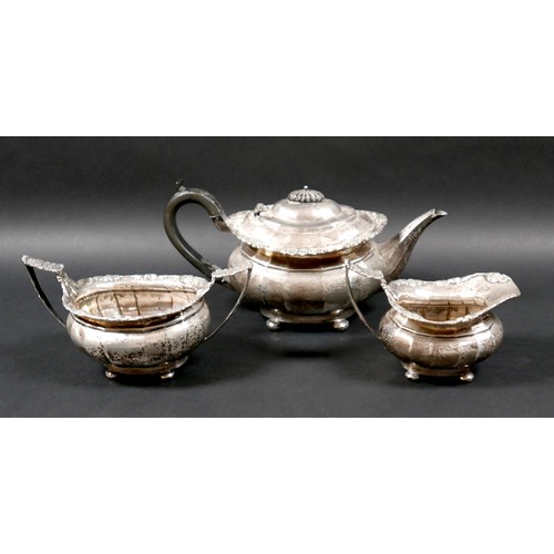 40 - An George V silver three piece tea service, with faceted bodies and fruiting vine cast rims, compris... 