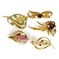 A group of five 9ct gold brooches of leaf design, set with various stones including rubies, garnets ... 