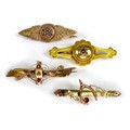 A group of four 9ct gold brooches, set with a variety of stones including rubies, diamond chips, and... 