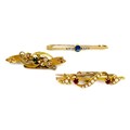 A group of three gold brooches, one set with a royal blue sapphire and diamond chips, 4.3cm, another... 